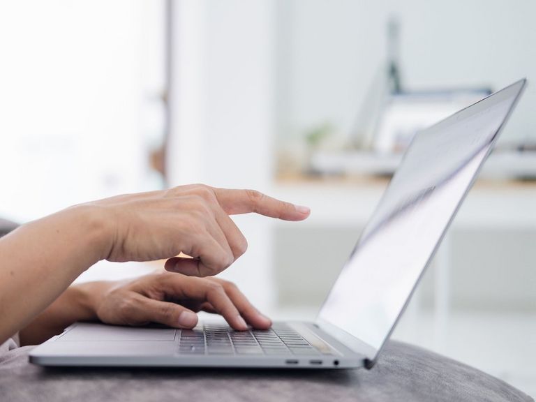 Frau zeigt mit dem Zeigefinger auf den Bildschirm eines Laptops