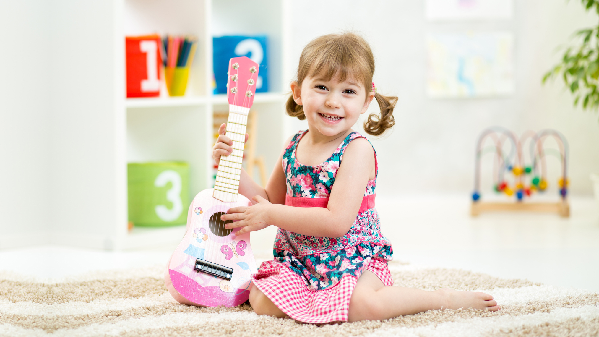 Kleines Mädchen übt auf einer Gitarre