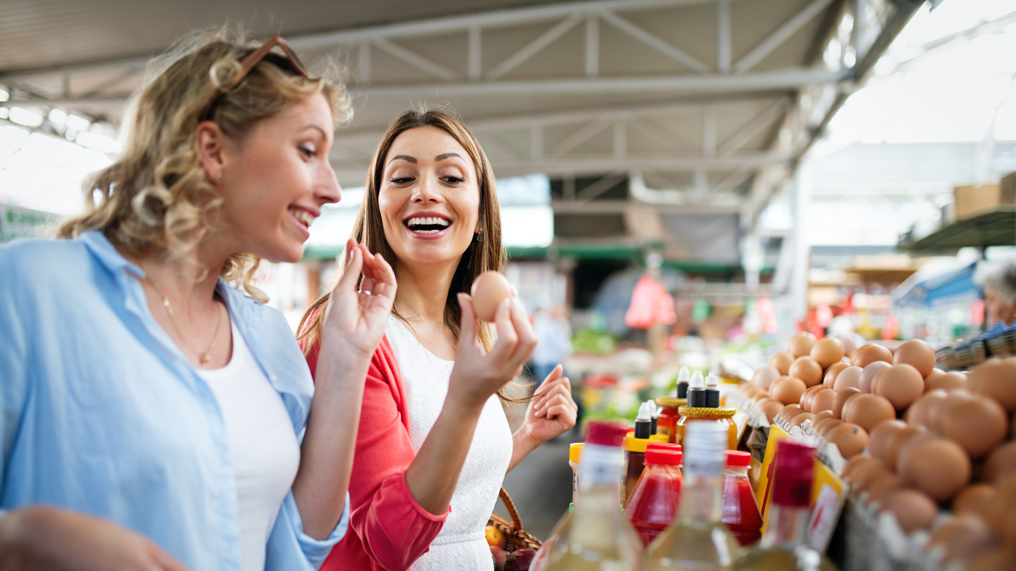 Zwei Frauen kaufen auf einem Biomarkt Lebensmittel