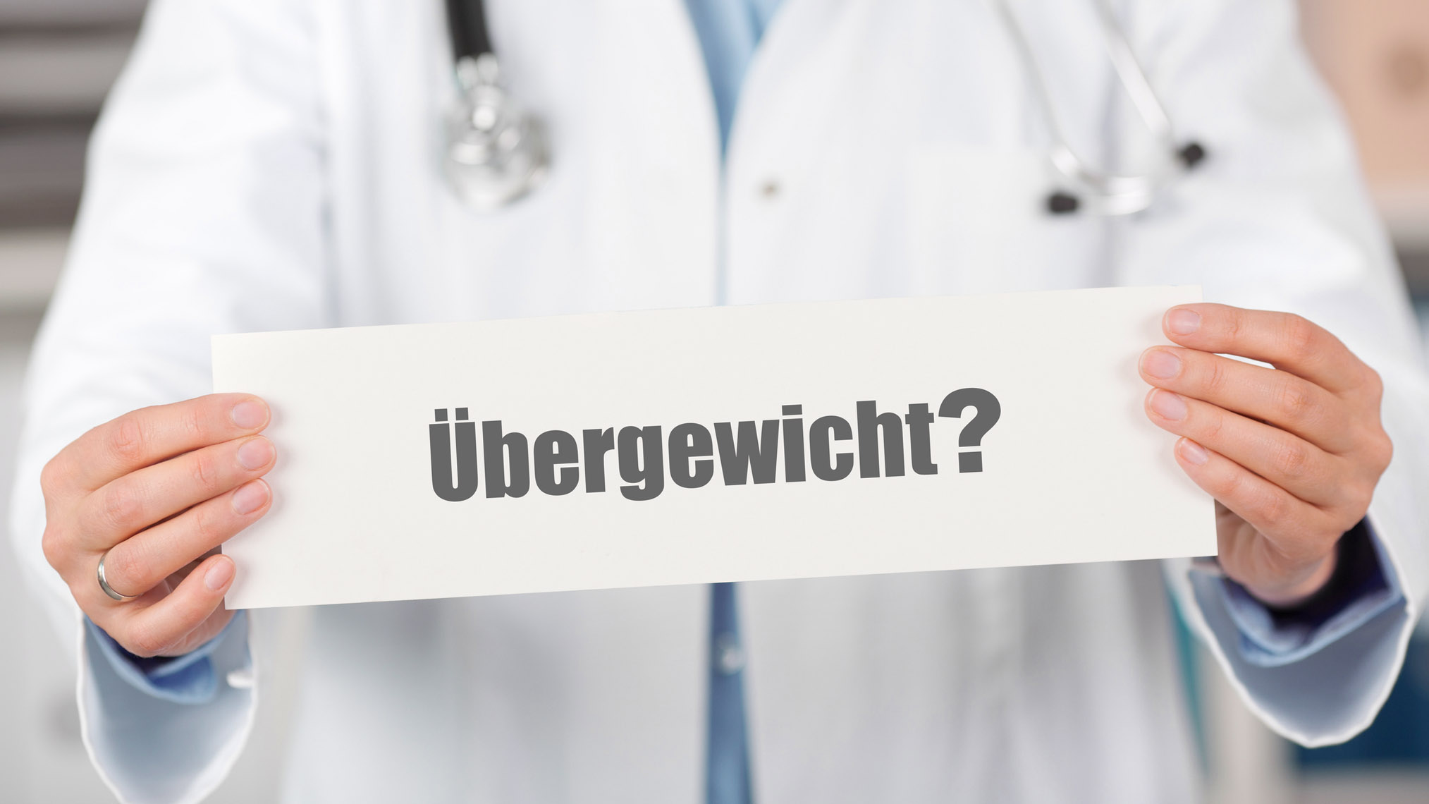 Arzt hält ein Schild mit der Aufschrift "Übergewicht"