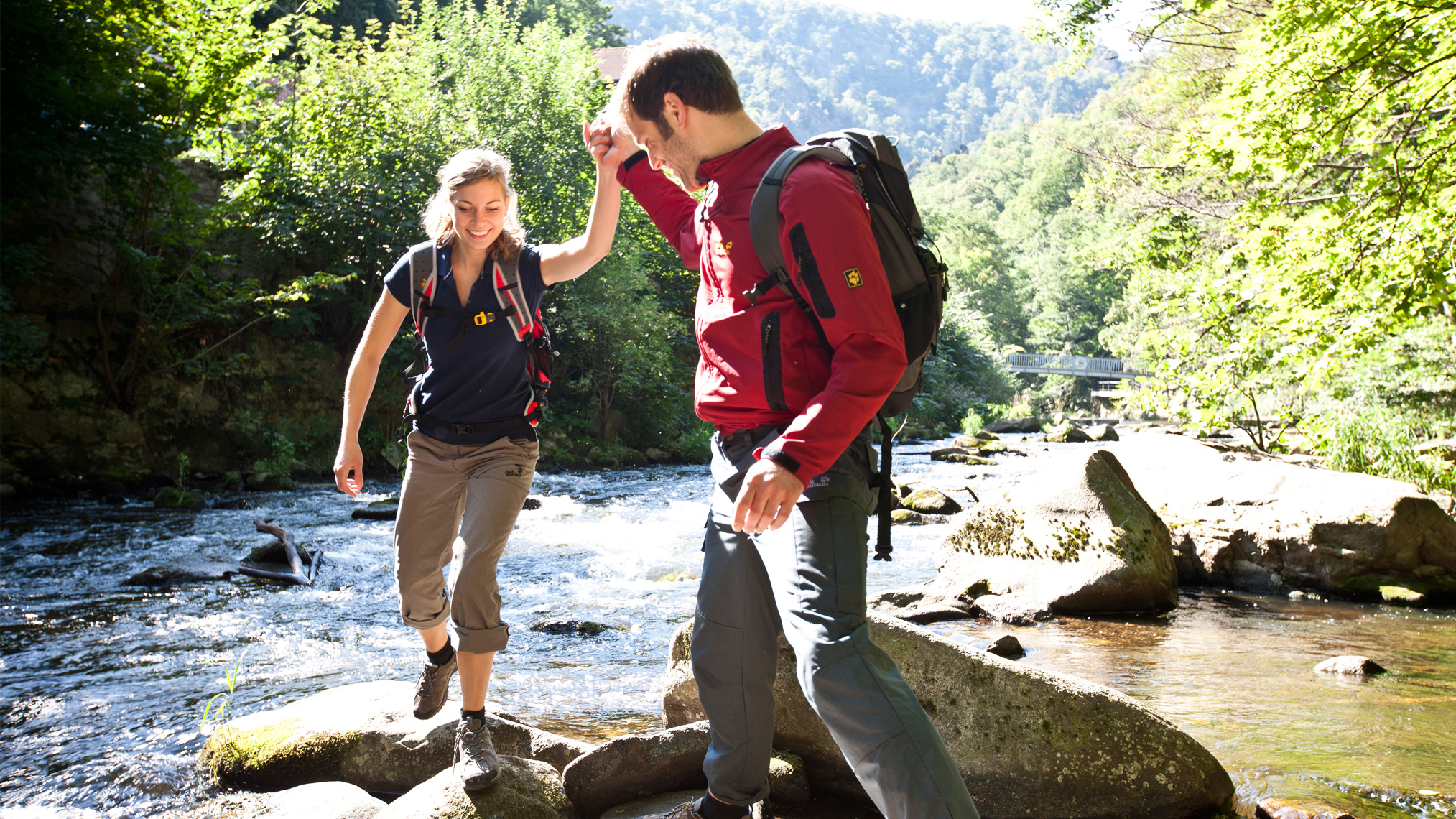 Mann und Frau wandern an einem Bach