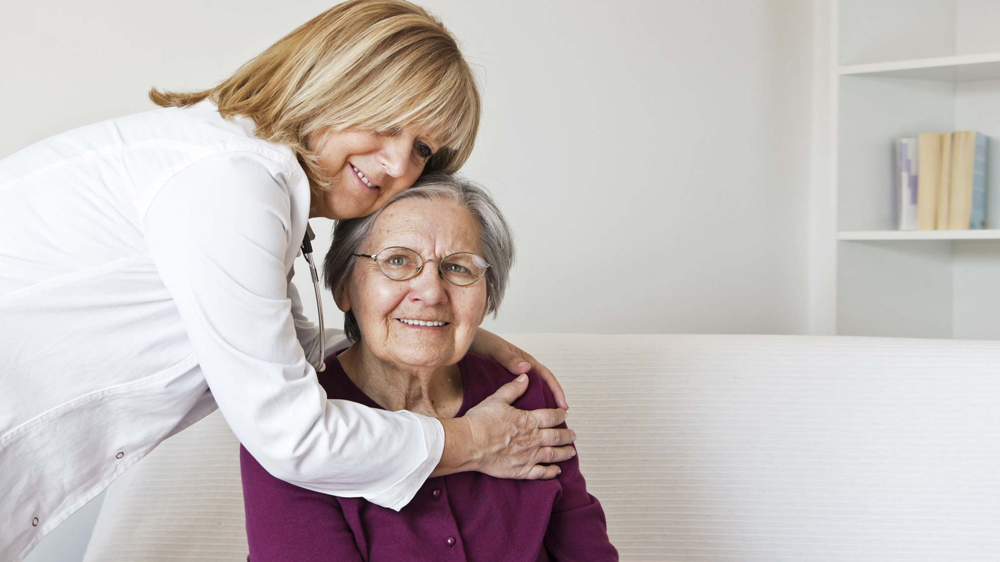 Pflegerin kümmert sich um Seniorin in der Wohnung