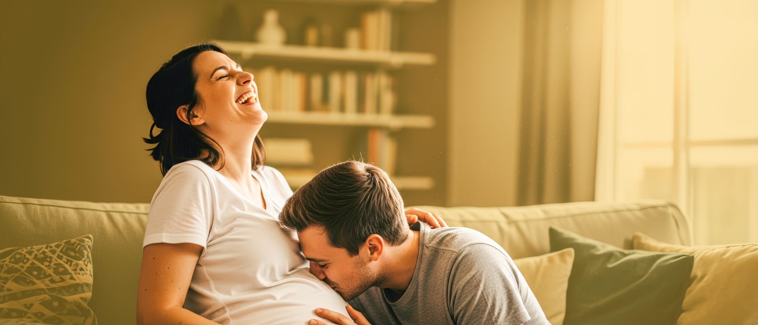 Bauchgefühlpaket Mann küsst den Babybauch einer lachenden Frau