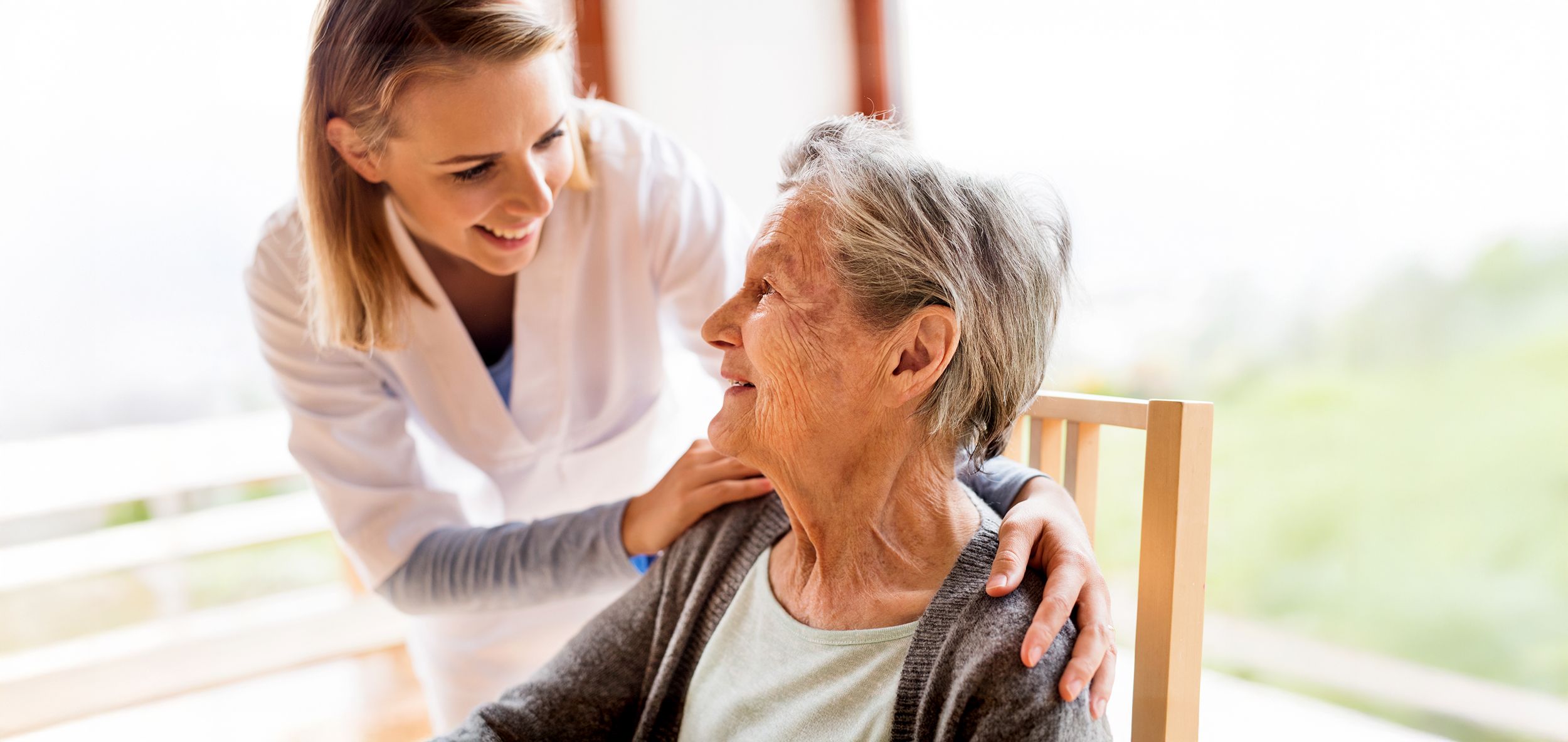 Pflegerin betreut fröhlich eine Pflegebedürftige