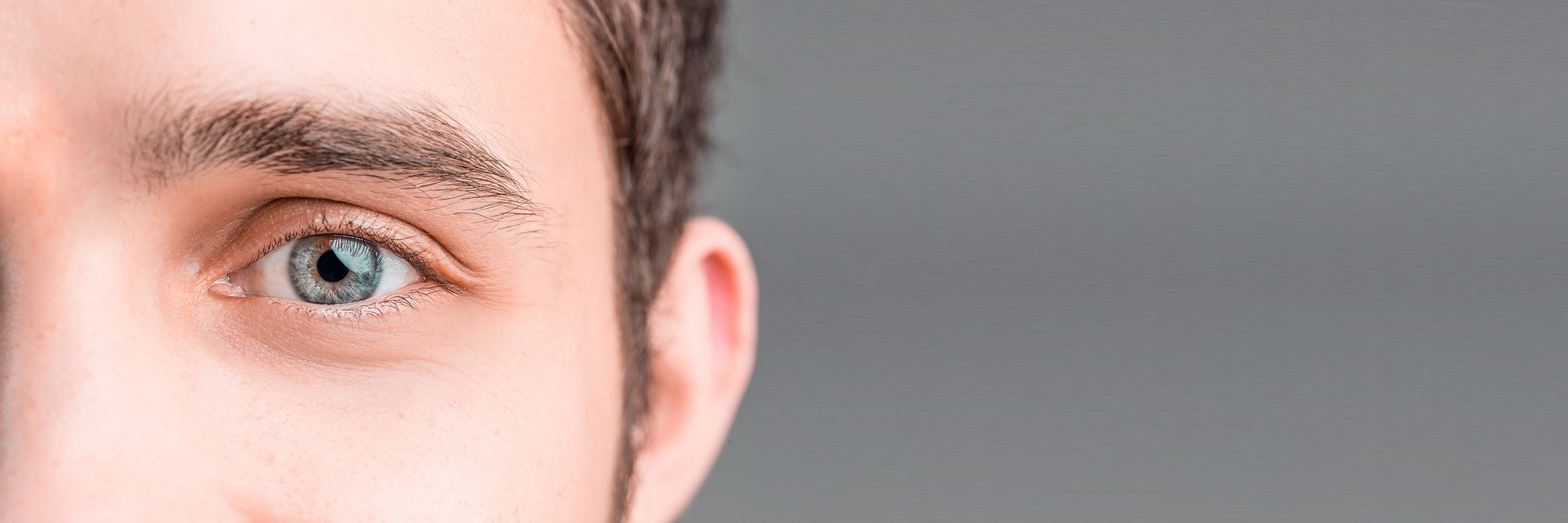 Nahaufnahme eines männlichen Gesichtsausschnitt mit Fokus auf eines der Augen