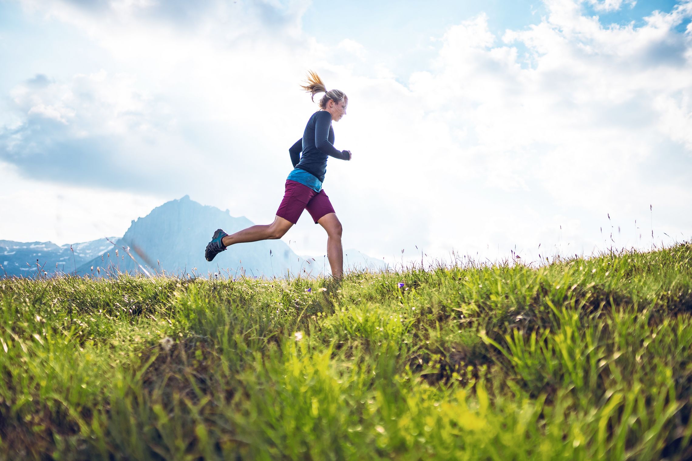 Sportliche Frau beim Trailrunning in den Bergen