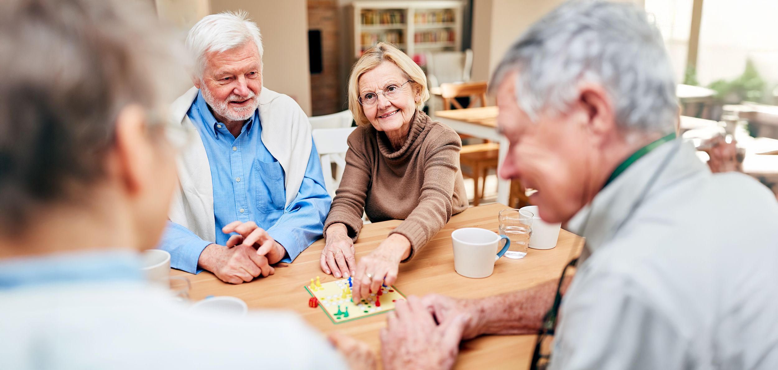 Wohngruppe mit Rentnerin beim gemeinsamen Spielen