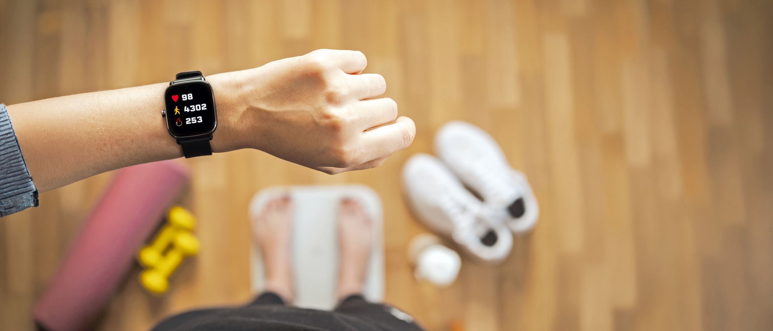 Arm einer Frau mit einer Smartwatch und die angezeigten Gesundheitsdaten