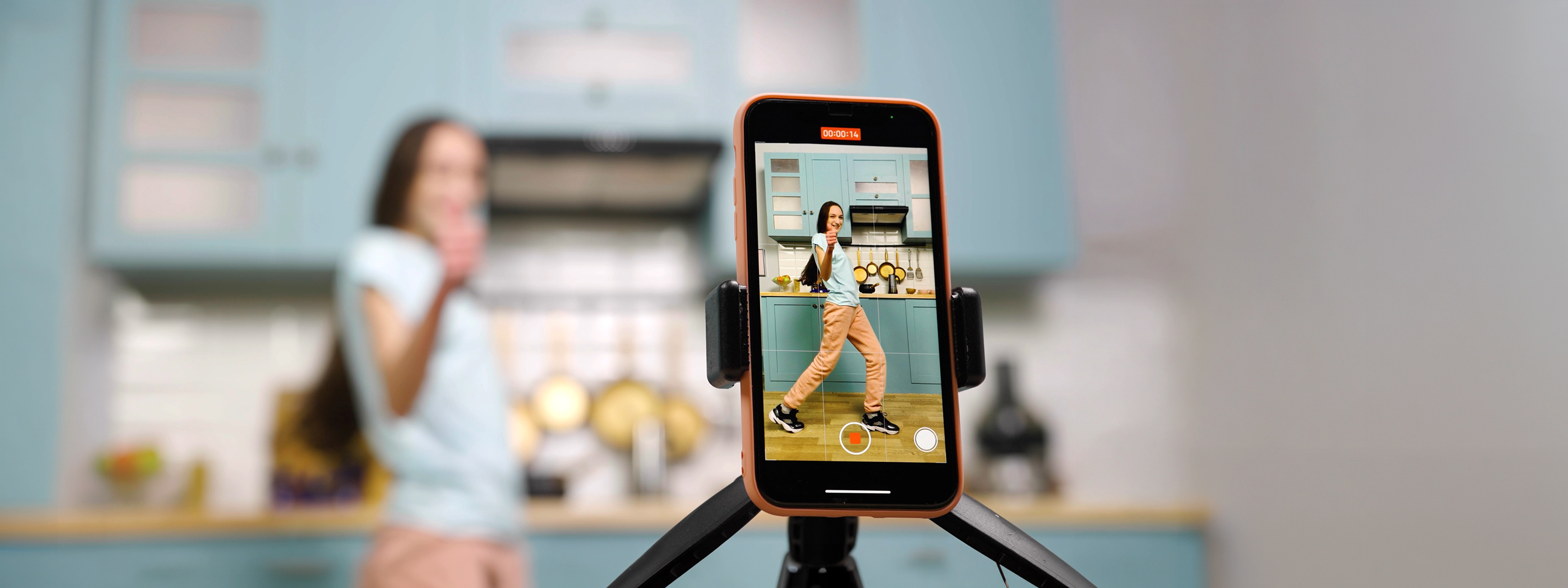 Frau in der Küche zeichnet einen Post für Instagram auf