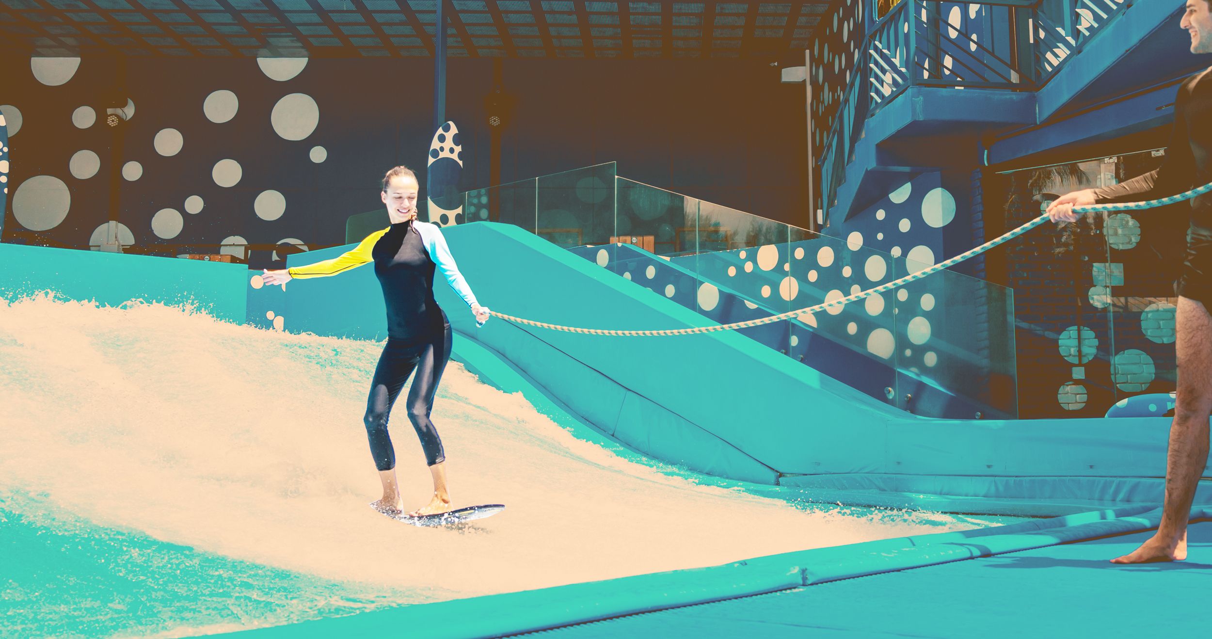 Junge Frau übt das Indoor-Surfen mit Sicherungsleine