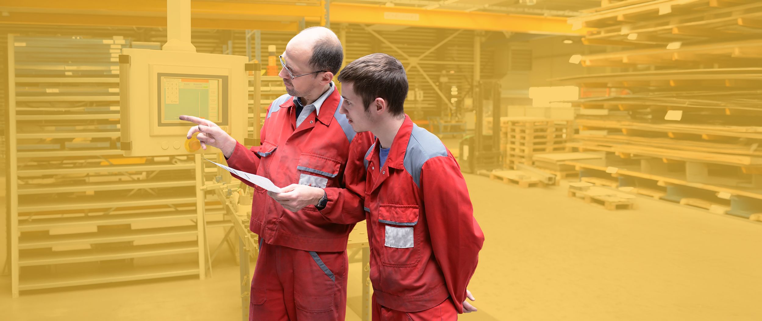 Der Chef erklärt dem Lehrling die Bedienung einer Maschine