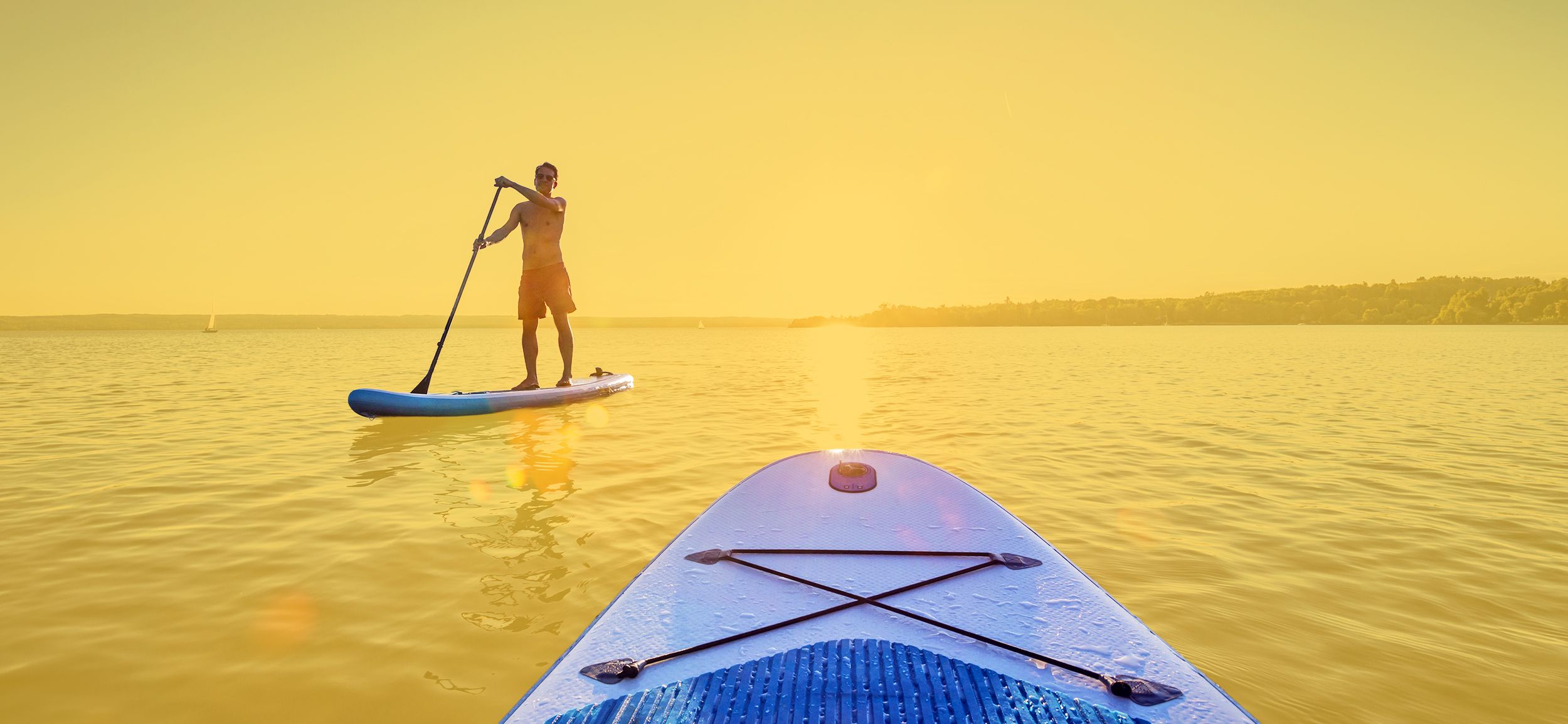 Standup-Paddler im Sonnuntergang auf dem See
