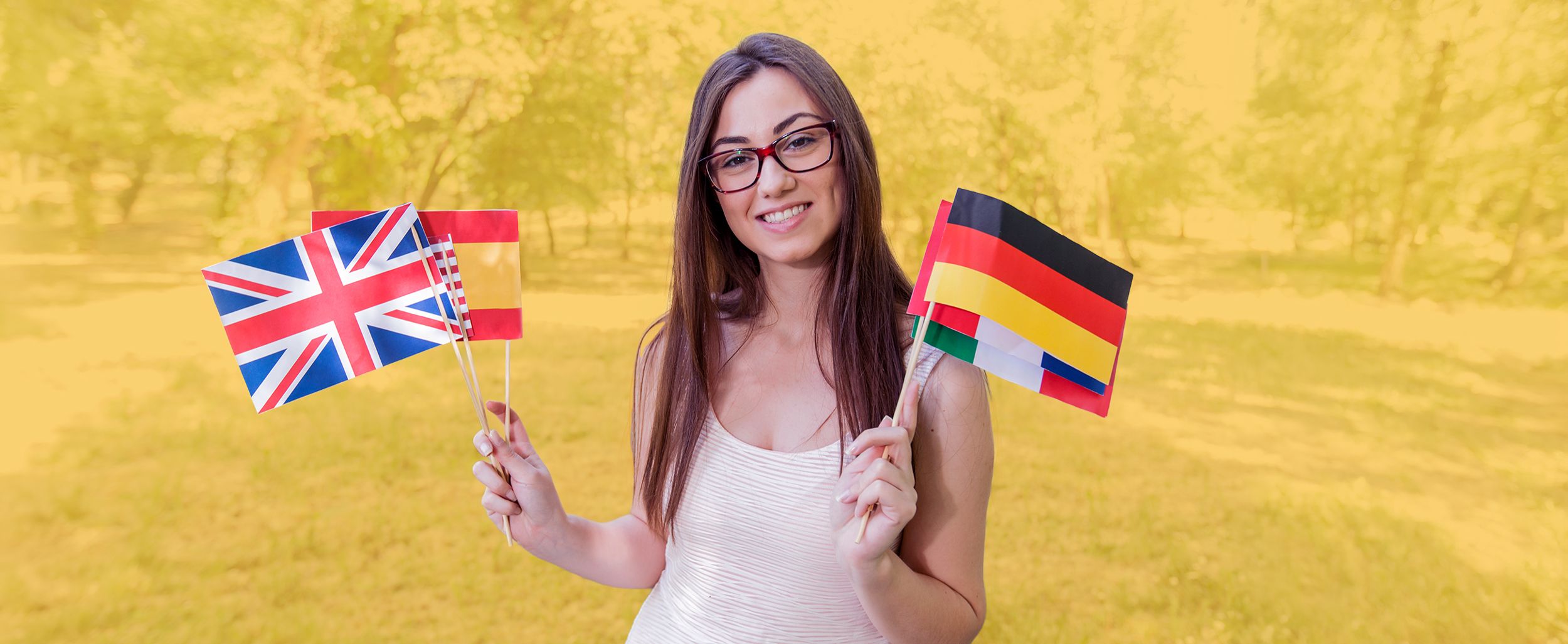 Junge Frau mit Brille hält verschiedenen kleine Flaggen-Fähnchen