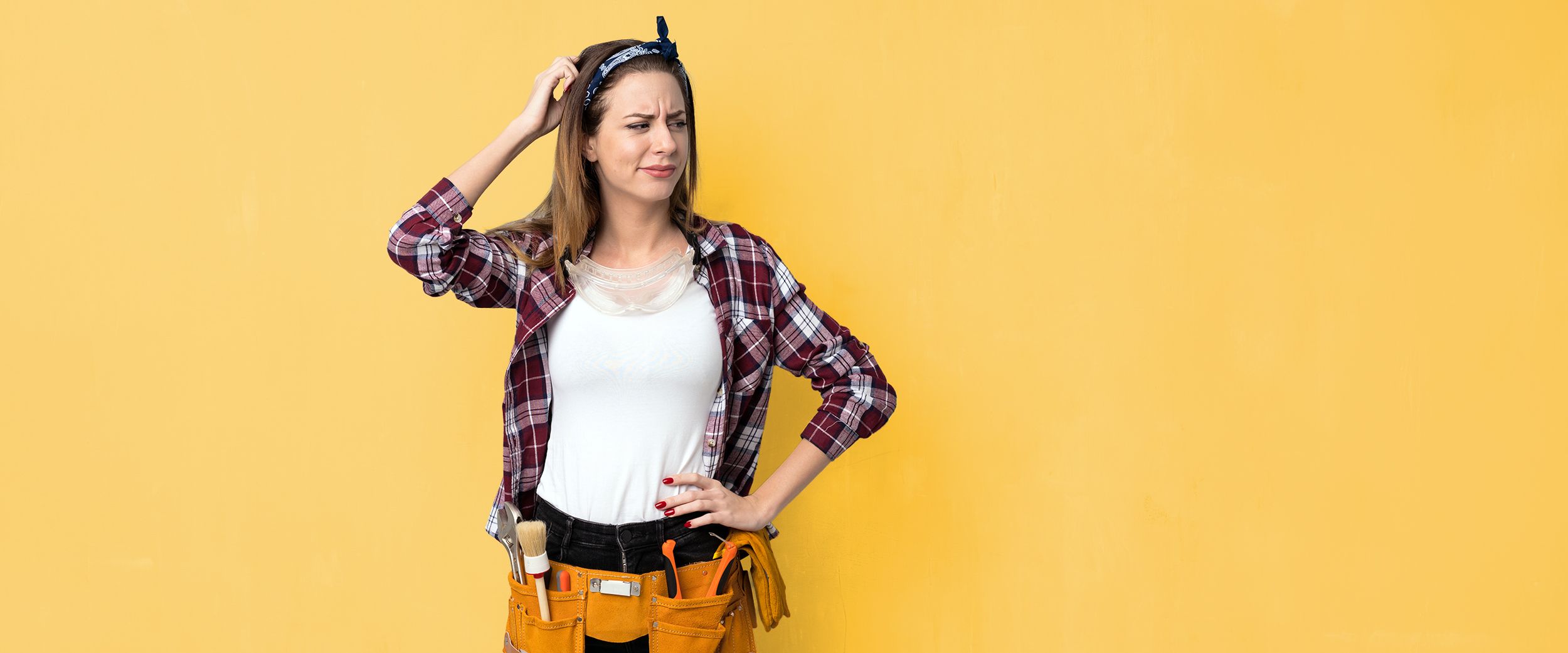 Auszubildende in Arbeitskleidung kratzt sich verlegen am Kopf