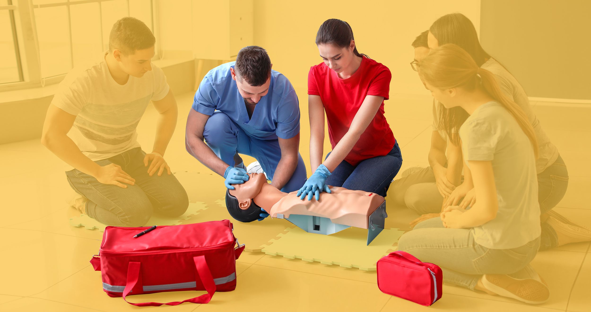 Teilnehmer beim Erste-Hilfe-Kurs an einer Beatmungspuppe