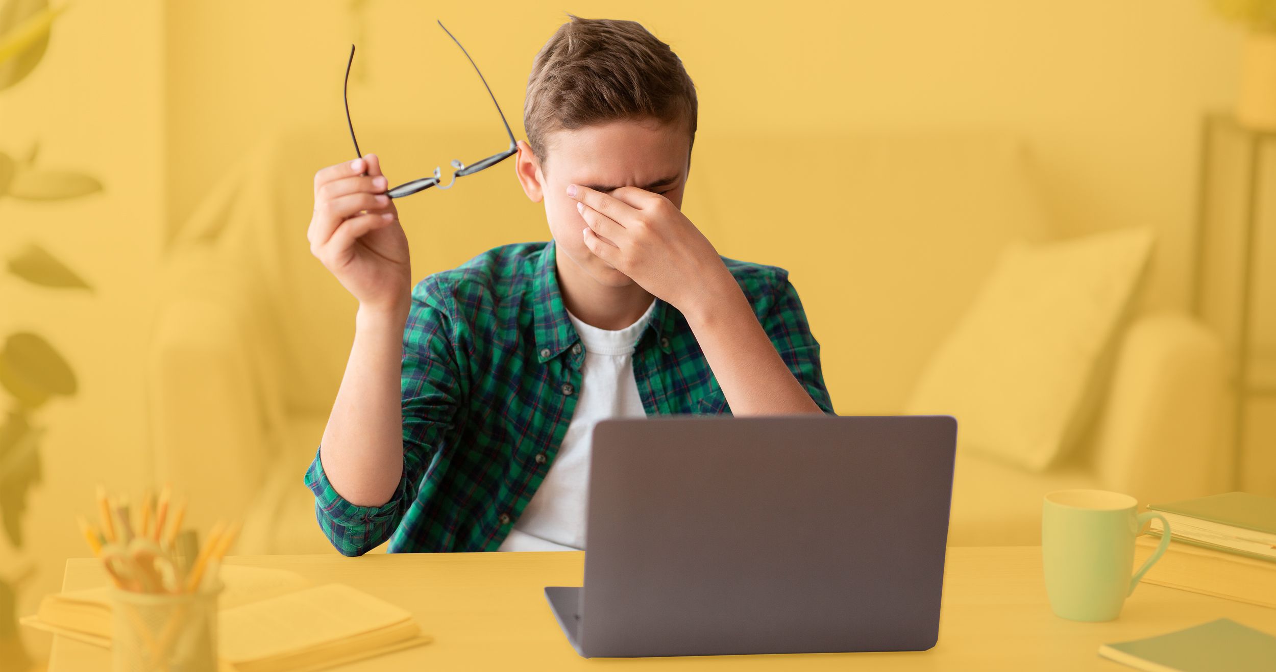 Teenager vor dem Laptop reibt sich die Augen