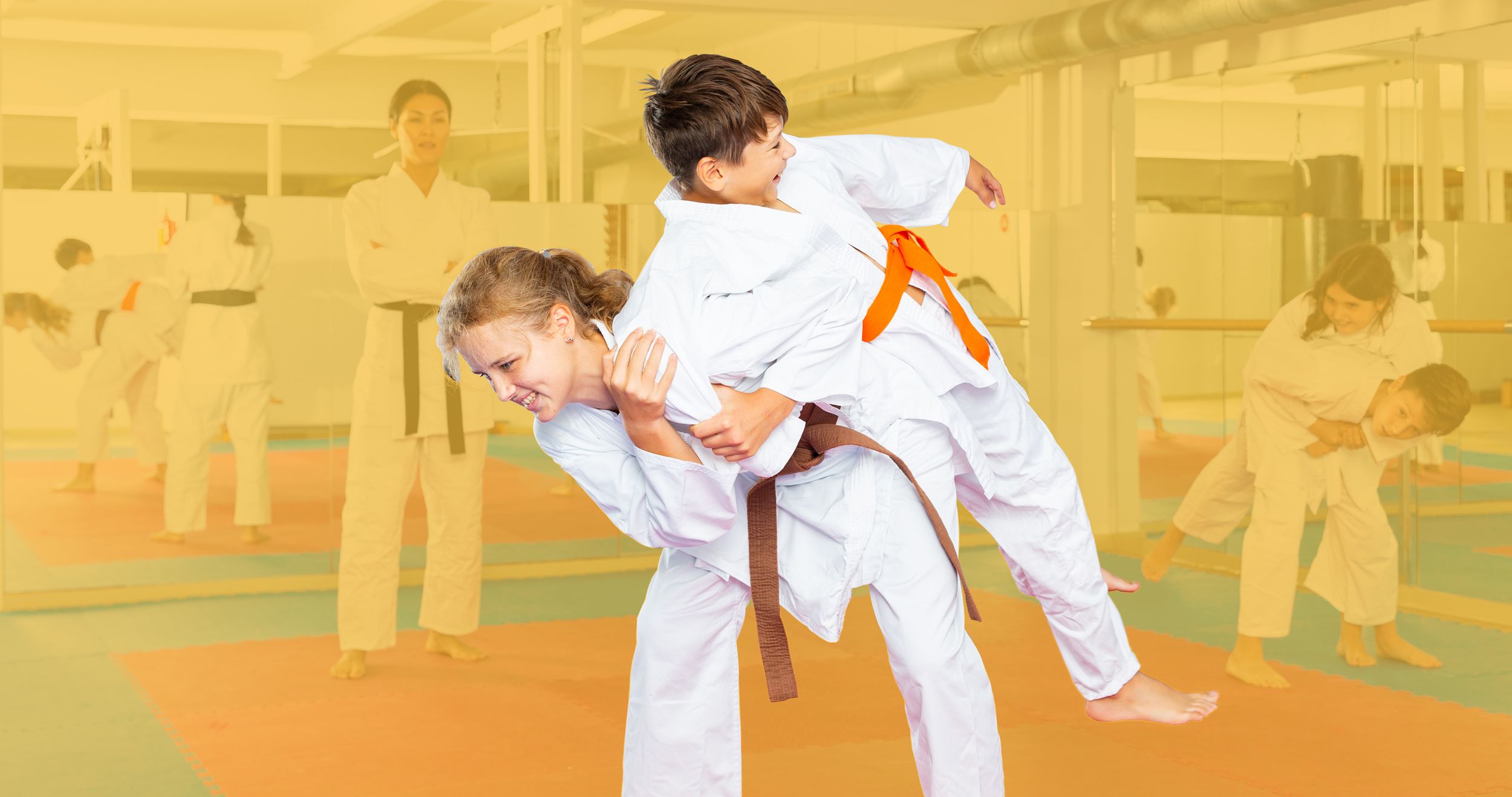 Trainerin der Selbstverteidigung mit ihren Schülern auf der Matte