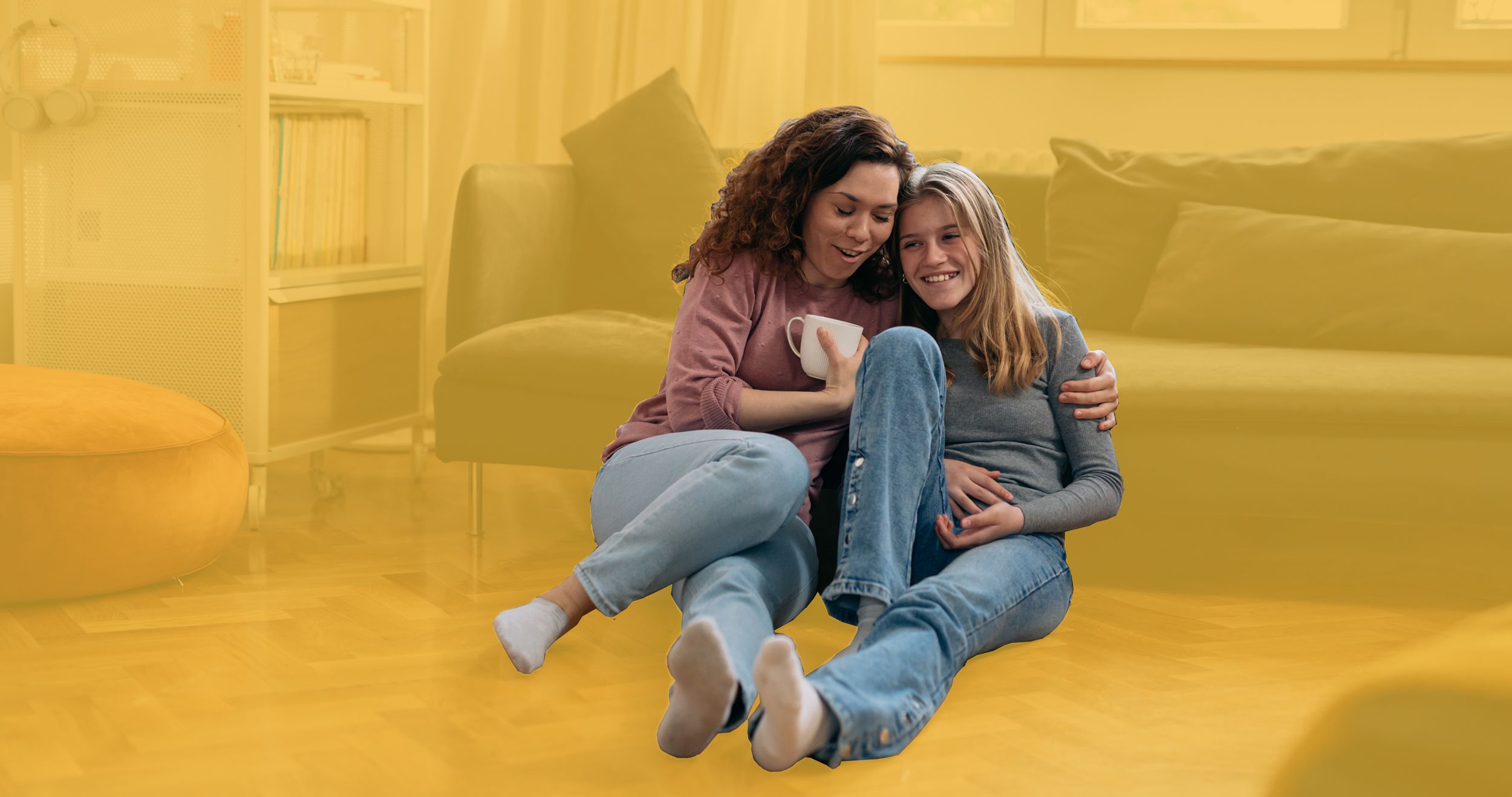 Mutter und Tochter sitzen im Wohnzimmer auf dem Boden