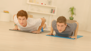 Zwei Jungs auf ihren Yoga-Matten in der Kobra-Pose