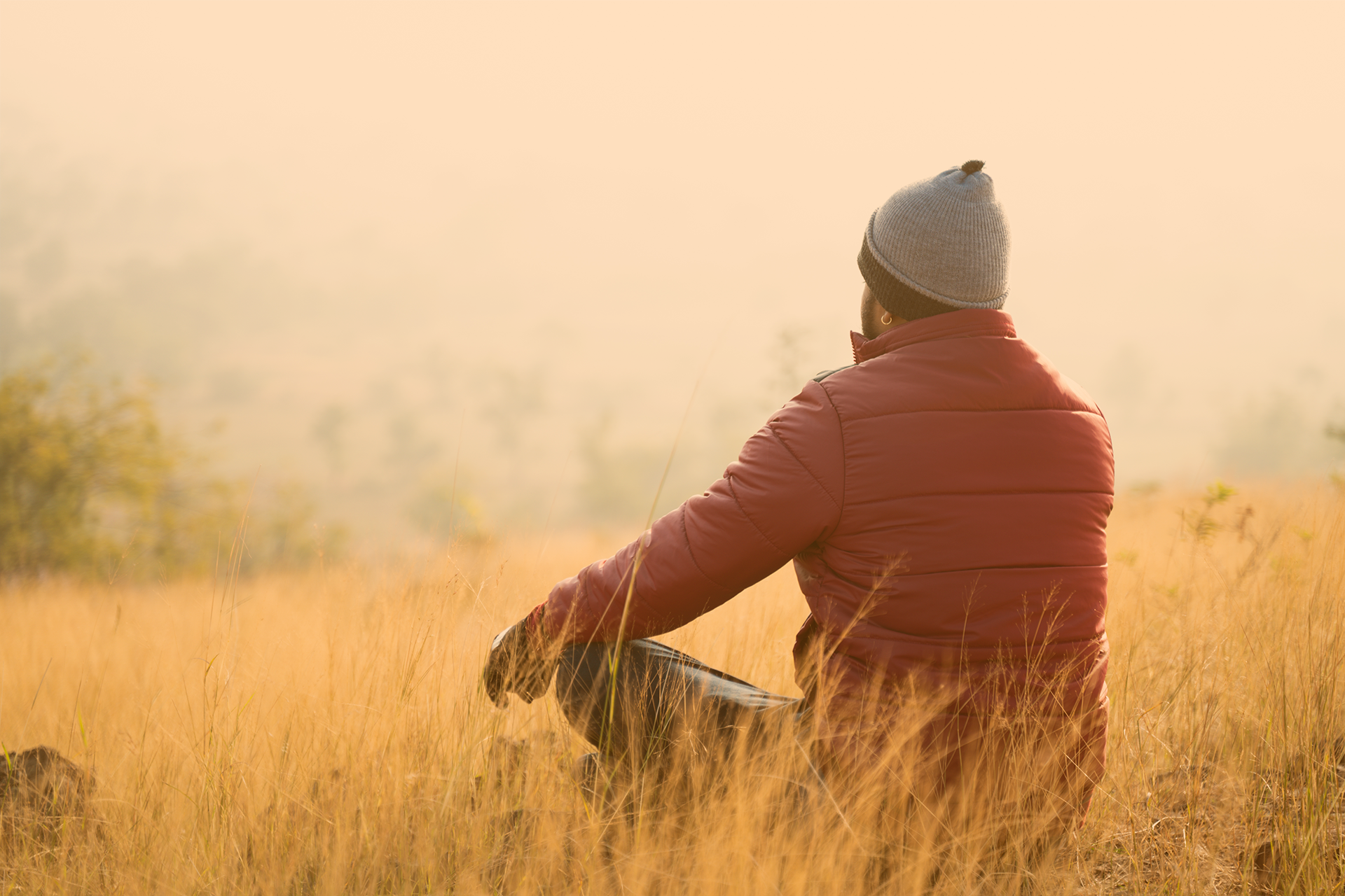 Jugendlicher sitz im Lotussitz auf einer herbstlichen Wiese und genieß den Moment 