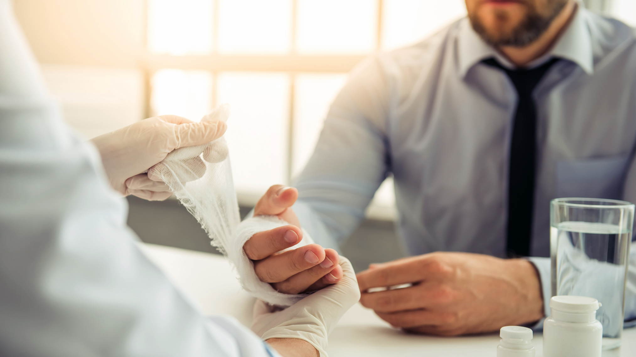 Ambulante ärztliche Versorgung Arzt verbindet die Hand eines Patienten