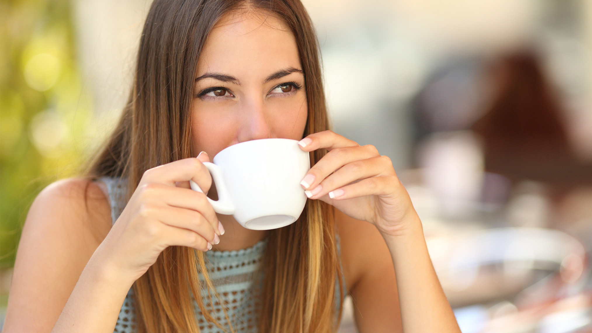 Getränke - Wissenswertes & Co. junge Frau trinkt Ihren Kaffee auf der Terasse eine Restaurants