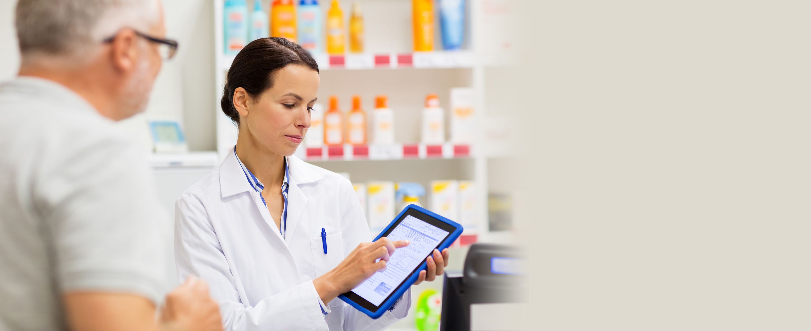 Elektronisches Rezept Apothekerin erklärt auf einem tablet einem Kunden das Elektronische Rezept