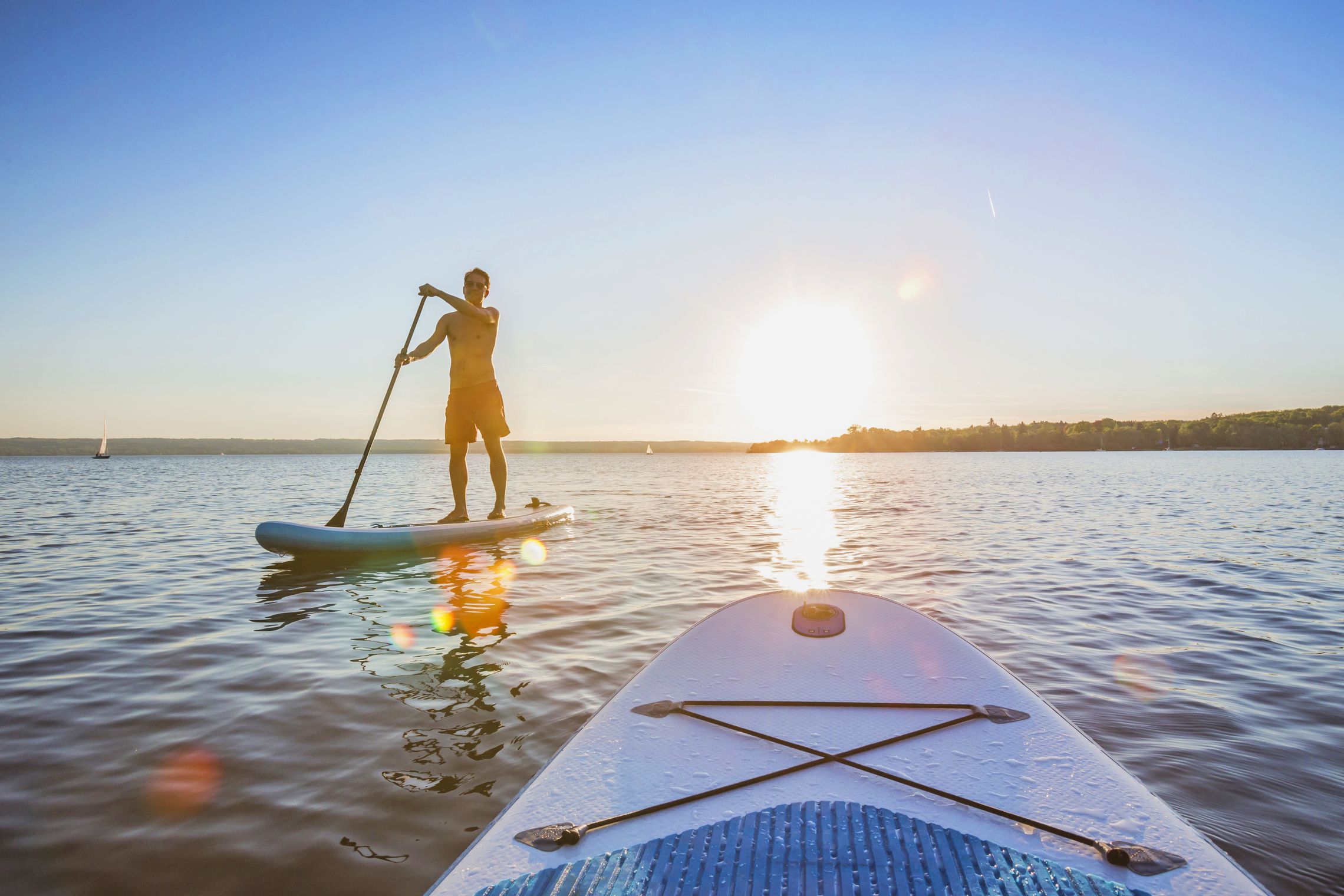 Stand up Paddler auf einem See beim Sonnenuntergang