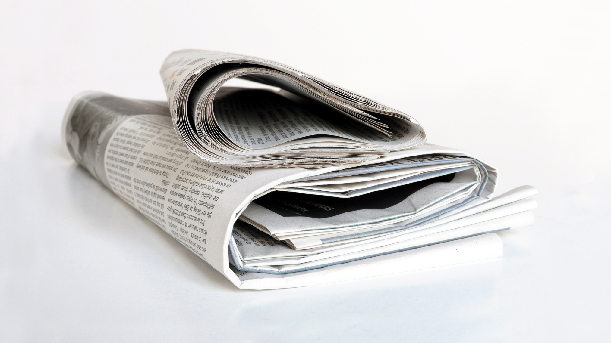 Pressemeldungen der IKK gesund plus Zeitungsstapel auf einem Tisch
