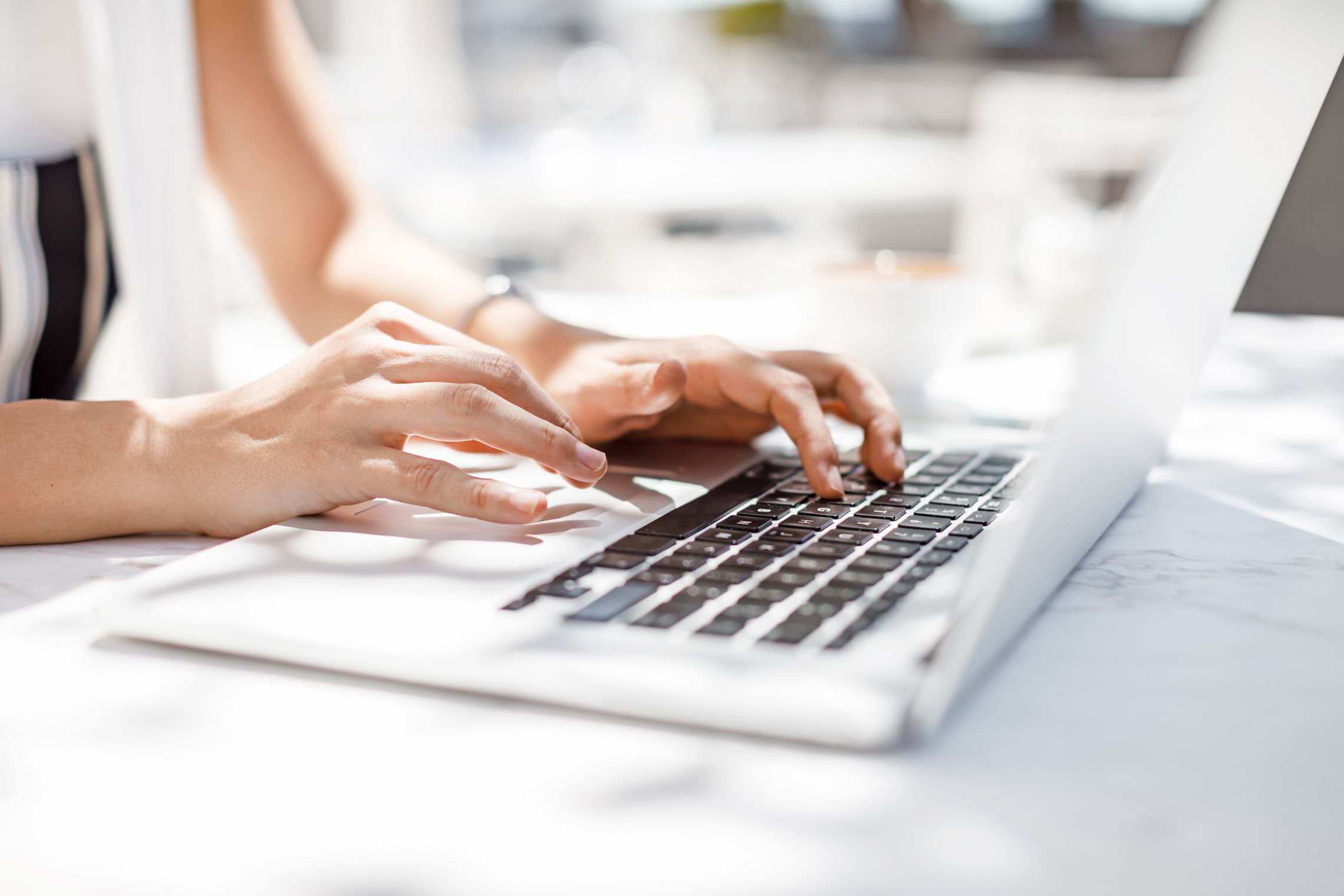Bildschirmarbeit Frauenhände, die auf einer Laptop-Tastatur einen Text tippen
